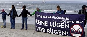 Mit einem Transparent und der Aufschrift „Für die Energiesicherheit notwendig? Keine Lügen vor Rügen“ stehen Menschen am Strand von Binz auf der Insel Rügen in einer Menschenkette als Protest gegen ein für die Insel vorgesehenes Flüssigerdgas-Terminal.  