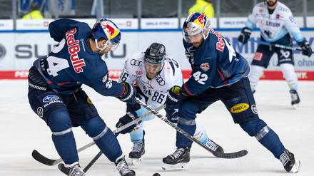 Aufgehalten. Daniel Pietta von Ingolstadt spiel den Puck gegen Jonathon Blum (l.) von München und Yasin Ehlitz.
