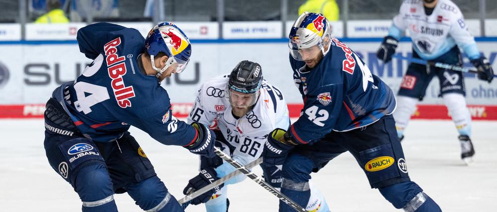 Aufgehalten. Daniel Pietta von Ingolstadt spiel den Puck gegen Jonathon Blum (l.) von München und Yasin Ehlitz.
