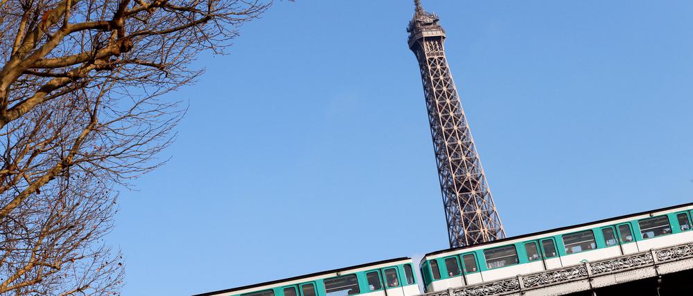 A picture taken on November 28, 2012 shows a train driving in front of the Eiffel Tower on an elevated railroad between the "Bir-Hakem" and the "Passy" metro stations in Paris. AFP PHOTO / PATRICK KOVARIK