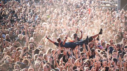 Festivalbesucher werden beim Wacken Open Air Festival beim Crowdsurfen über die Menge getragen.
