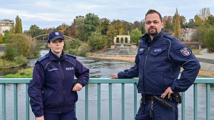 Julita Cholewinska, Polizistin bei der polnischen Polizei und Holger Welkisch, Polizeibeamter, stehen während ihrer gemeinsamen Streife auf der Neißebrücke zwischen Gubin (Polen) und Guben (Deutschland). Viel Praxiserfahrung konnte das deutsch-polnische Polizeiteam in Guben und Gubin bisher nicht sammeln - Corona legte die neu gebildete gemeinsame Streife Monate auf Eis. Nun ist sie wieder auf der Straße.