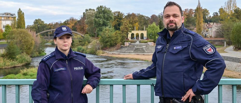 Julita Cholewinska, Polizistin bei der polnischen Polizei und Holger Welkisch, Polizeibeamter, stehen während ihrer gemeinsamen Streife auf der Neißebrücke zwischen Gubin (Polen) und Guben (Deutschland). Viel Praxiserfahrung konnte das deutsch-polnische Polizeiteam in Guben und Gubin bisher nicht sammeln - Corona legte die neu gebildete gemeinsame Streife Monate auf Eis. Nun ist sie wieder auf der Straße.