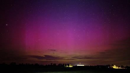 Polarlichter flackern am nächtlichen Himmel über dem kleinen Dorf im Havelland.