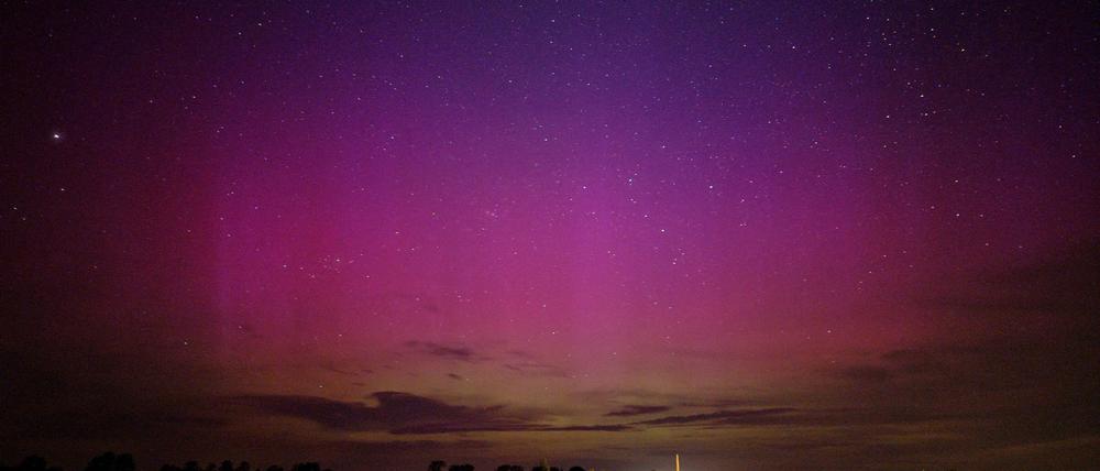 Polarlichter flackern am nächtlichen Himmel über dem kleinen Dorf im Havelland.