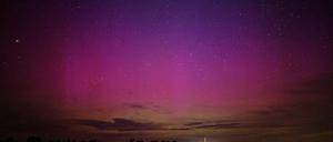 Polarlichter flackern am nächtlichen Himmel über dem kleinen Dorf im Havelland.