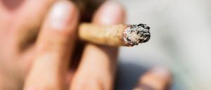 Ein Mann raucht bei einer Demonstration für eine zügige Legalisierung von Cannabis einen Joint mit Medizinalcannabis.
