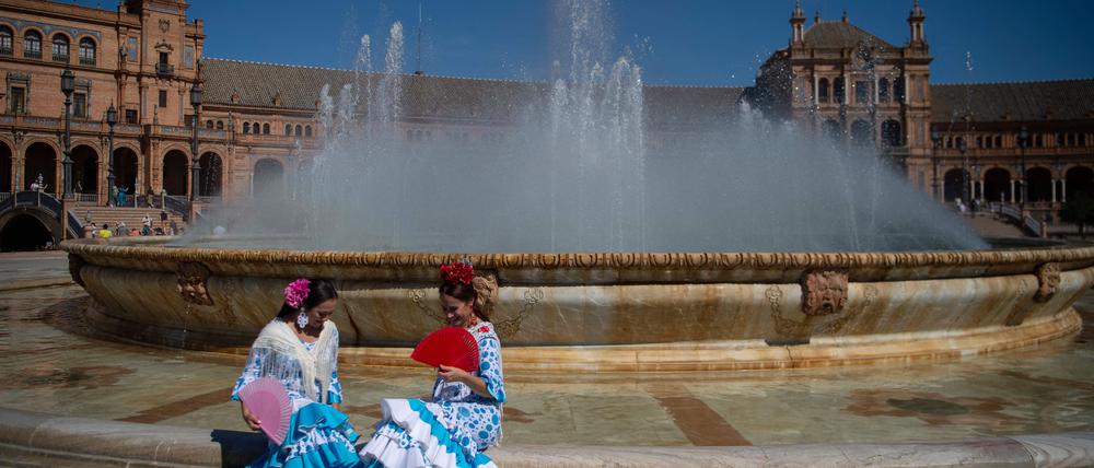 In Sevilla sitzen zwei Frauen vor einem Brunnen.