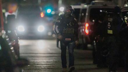 Polizisten gehen zu den Einsatzfahrzeugen nach der Beendigung einer Geiselnahme in einem Geschäft an der Keithstraße. Dort war es Ende April zu einem Überfall auf ein Geschäft gekommen, bei dem auch eine Geisel genommen wurde.