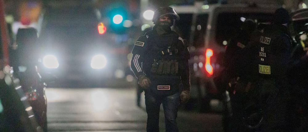Polizisten gehen zu den Einsatzfahrzeugen nach der Beendigung einer Geiselnahme in einem Geschäft an der Keithstraße. Dort war es Ende April zu einem Überfall auf ein Geschäft gekommen, bei dem auch eine Geisel genommen wurde.