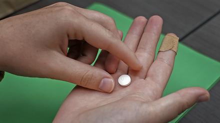 Eine Patientin bereitet sich darauf vor, die erste von zwei Kombinationspillen für einen medikamentösen Schwangerschaftsabbruch während eines Besuchs in einer Klinik zu nehmen. 