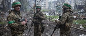 Ukrainische Soldaten unterhalten sich auf der Straße in der vom Krieg betroffenen Stadt.