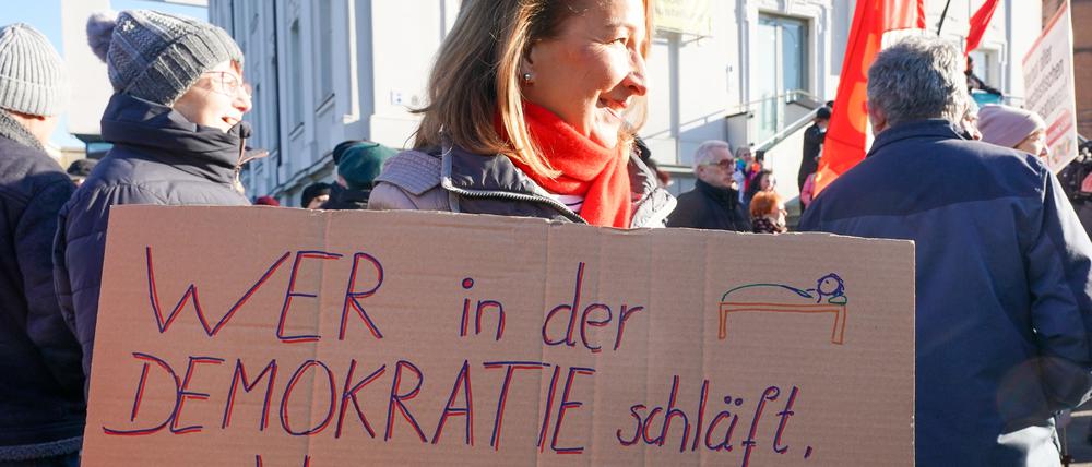 Thüringen, Gera: Eine Demonstrantin hält ein Plakat mit der Aufschrift «wer in der Demokratie schläft, wacht in derr Diktatur auf» während einer Kundgebung und Demonstration unter dem Motto «Für ein weltoffenes Thüringen - Gegen faschistische Paktierereien».