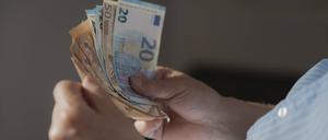 Ein Mann hält mehrere Euroscheine in der Hand.
