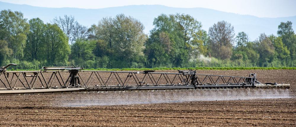 Ein Traktor mit einem GPS-Lenksystem bringt auf einem Acker Pflanzenschutzmittel aus.