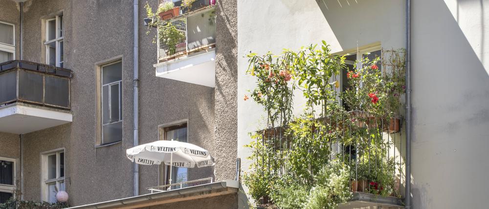 Fassade eines Mietshauses mit Balkon und Bepflanzungen.