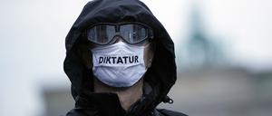 Ein Teilnehmer einer Demonstration gegen die Corona-Einschränkungen der Bundesregierung trägt eine Mund-Nasen-Bedeckung mit der Aufschrift „Diktatur“. 