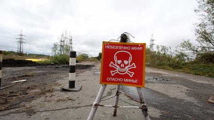Ein Schild warnt vor Minen in ehemals besetztem Gebiet in der Region Charkiw.