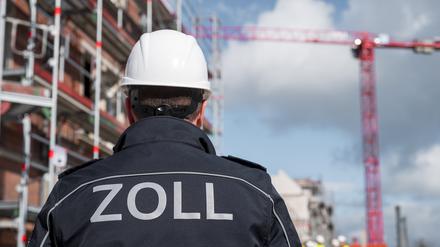 Eine Einsatzkraft des Zolls steht vor einer Baustelle. Schwarzarbeit gehört zu den häufigsten Wirtschaftsdelikten.