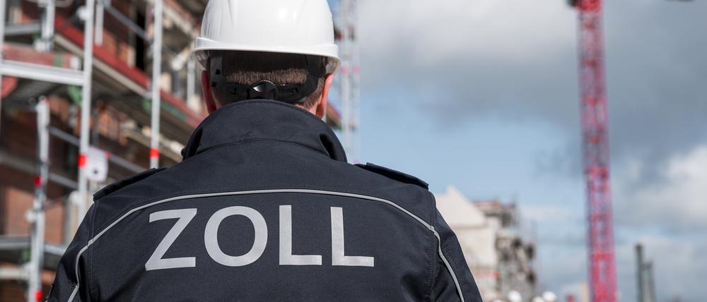 Eine Einsatzkraft des Zolls steht vor einer Baustelle. Schwarzarbeit gehört zu den häufigsten Wirtschaftsdelikten.