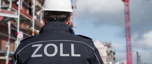 Eine Einsatzkraft des Zolls steht vor einer Baustelle. Schwarzarbeit gehört zu den häufigsten Wirtschaftsdelikten.