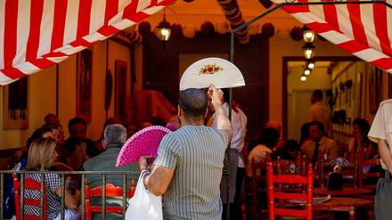 Spanien, Sevilla: Ein Mann verkauft an einem heißen Tag auf der April-Messe in Sevilla Fächer.
