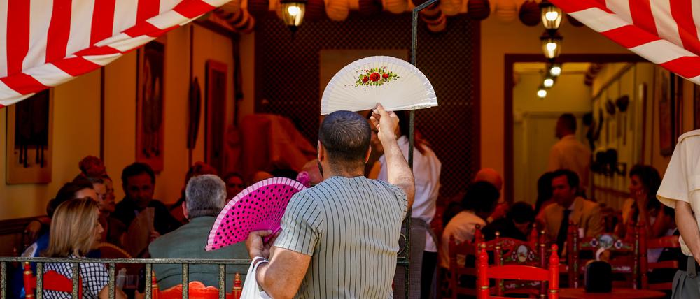 Spanien, Sevilla: Ein Mann verkauft an einem heißen Tag auf der April-Messe in Sevilla Fächer.