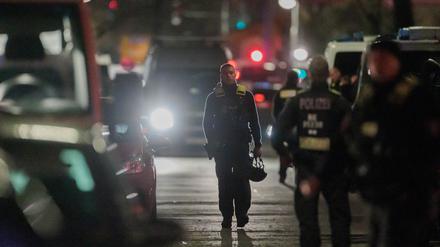 25.04.2023, Berlin: Polizisten gehen zu den Einsatzfahrzeugen nach der Beendigung einer Geiselnahme in einem Geschäft an der Keithstraße. Dort war es zu einem Überfall auf ein Geschäft gekommen, bei dem auch eine Geisel genommen wurde. Foto: Carsten Koall/dpa +++ dpa-Bildfunk +++