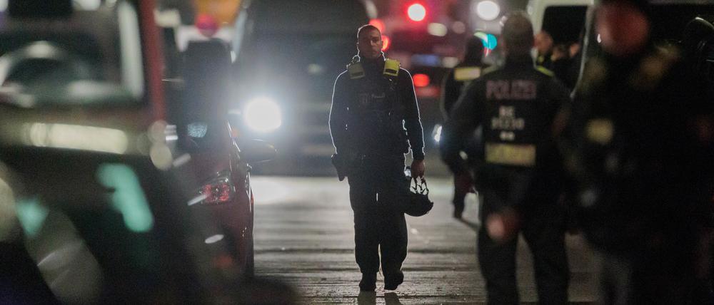 25.04.2023, Berlin: Polizisten gehen zu den Einsatzfahrzeugen nach der Beendigung einer Geiselnahme in einem Geschäft an der Keithstraße. Dort war es zu einem Überfall auf ein Geschäft gekommen, bei dem auch eine Geisel genommen wurde. Foto: Carsten Koall/dpa +++ dpa-Bildfunk +++