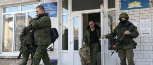 Dieses von der russischen Staatsagentur Tass verbreitete Bild zeigt Männer, die aus einer Rekrutierungsstation heraustreten (Archivfoto).