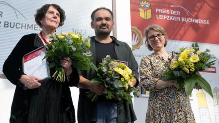 27.04.2023, Sachsen, Leipzig: Autorin Regina Scheer (v.l.), erhält den Preis der Leipziger Buchmesse in der Kategorie Sachbuch/Essayistik, Autor Dinçer Güçyeter, erhält den Preis der Leipziger Buchmesse in der Kategorie Belletristik, und Johanna Schwering, erhält den Preis der Leipziger Buchmesse in der Kategorie Übersetzung und stehen während der Verleihung des Leipziger Buchpreises 2023 in der Glashalle auf der Bühne. Der Preis der Leipziger Buchmesse wird in den drei Kategorien Belletristik, Sachbuch/Essayistik und Übersetzung vergeben und ist mit insgesamt 60 000 Euro dotiert. Foto: Hendrik Schmidt/dpa +++ dpa-Bildfunk ++
