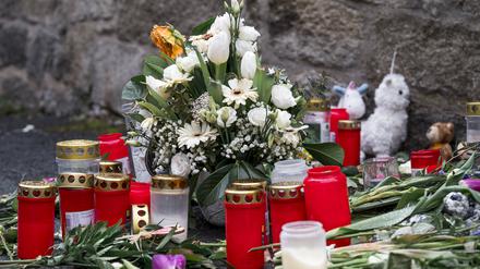 An der Straßenecke zur Zufahrtsstraße zum Kinder- und Jugendhilfezentrum, in dem eine Zehnjährige tot aufgefunden wurde, liegen Blumen, Kuscheltiere und Grablichter auf dem Gehweg.