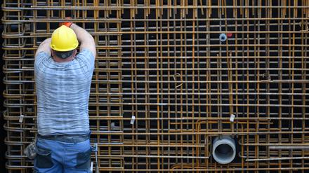 Ein Bauarbeiter ist auf einer Baustelle beschäftigt. 