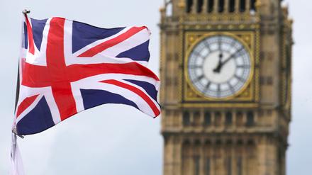 Eine britische Fahne weht vor dem berühmten Uhrturm Big Ben. 