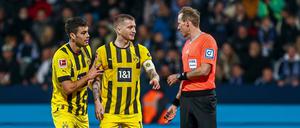 Marco Reus (Mitte) und Giovanni Reyna haben Diskussionsbedarf mit Schiedsrichter Sascha Stegemann.