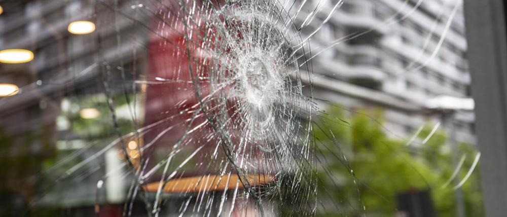 29.04.2023, Berlin: Eine beschädigte Glasscheibe ist an einem Haus an der Seydelstraße in Berlin-Mitte zu sehen. Wie die Polizei mitteilt, zogen etwa 20 Personen in der Nacht zum Samstag durch die Seydelstraße und beschädigten mindestens 18 Fahrzeuge, zerstörten zahlreiche Scheiben an Häusern und verübten auch einen Farbanschlag auf ein Job Center. Zwei Personen seien festgenommen worden, sagte ein Polizeisprecher. Foto: Paul Zinken/dpa +++ dpa-Bildfunk +++