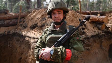 Ein russischer Soldat steht in einem Schützengraben.
