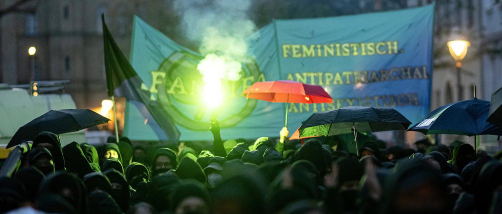 Teilnehmerinnen der linken Demonstration „Take back the night“ in Berlin-Kreuzberg verwenden Regenschirme als Sichtschutz.