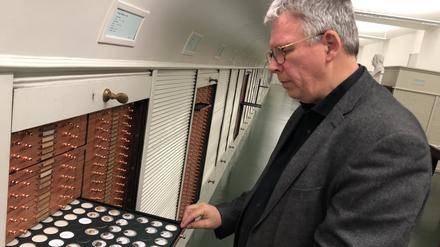 Prof. Bernhard Weisser, Direktor des Münzkabinetts, im Tresorraum der Sammlung, mit Münzen der antiken Stadt Lampsakos. 