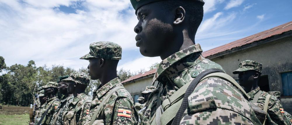 Ugandan soldiers of the East African Community Regional Force (EACRF) stand in formation in Bunagana, Democratic Republic of Congo, on April 19, 2023. - An East African force set up to thwart insurgents in Democratic Republic of Congo has for months been proclaiming progress, saying the rebels have quit key strongholds and been replaced by its troops. But these upbeat announcements contrast with the situation on the ground, where the rebels remain at large and more than a million people displaced by their advance are still in limbo. (Photo by Glody MURHABAZI / AFP)