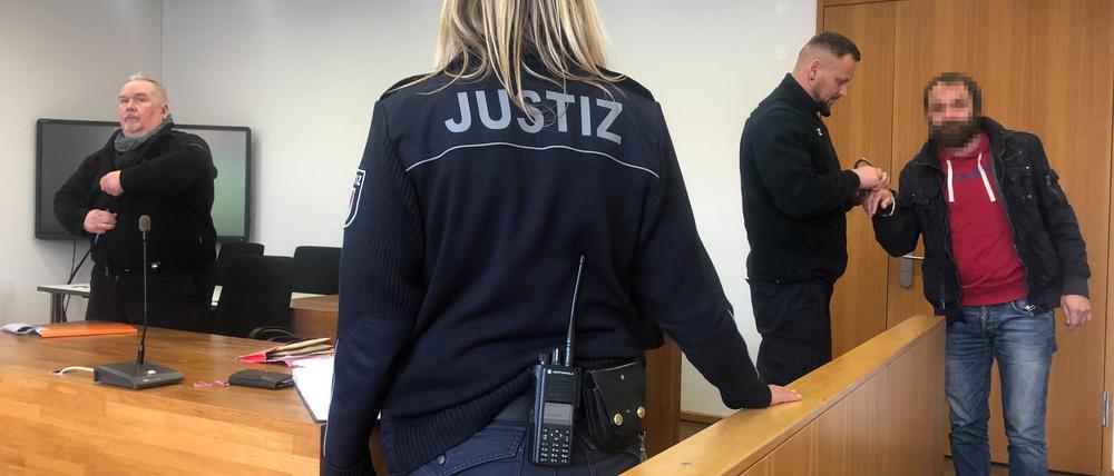 Vor Prozessbeginn wurde der Angeklagte (r.) noch in Handschellen vorgeführt. 