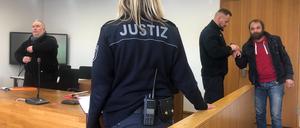 Vor Prozessbeginn wurde der Angeklagte (r.) noch in Handschellen vorgeführt. 
