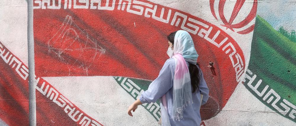Eine iranische Frau läuft auf der Straße.