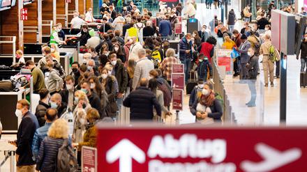 Zahlreiche Fluggäste warten im Terminal 1 des Flughafens BER in einer Schlange auf die Sicherheitskontrolle.