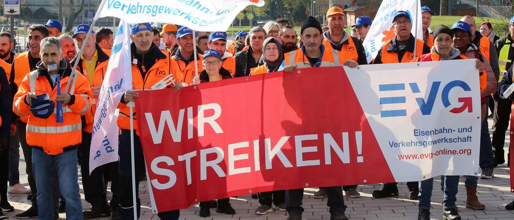 Warnstreikende der Eisenbahn- und Verkehrsgewerkschaft EVG stehen bei einer Kundgebung vor dem Bahnhof Dammtor zusammen.