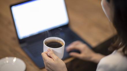 Eine Frau hält eine Kaffeetasse in ihrer Hand.