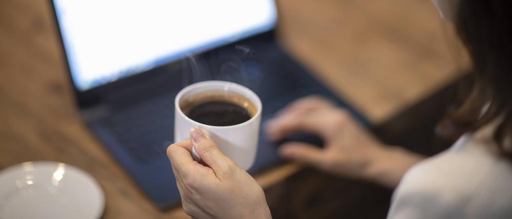 Eine Frau hält eine Kaffeetasse in ihrer Hand.