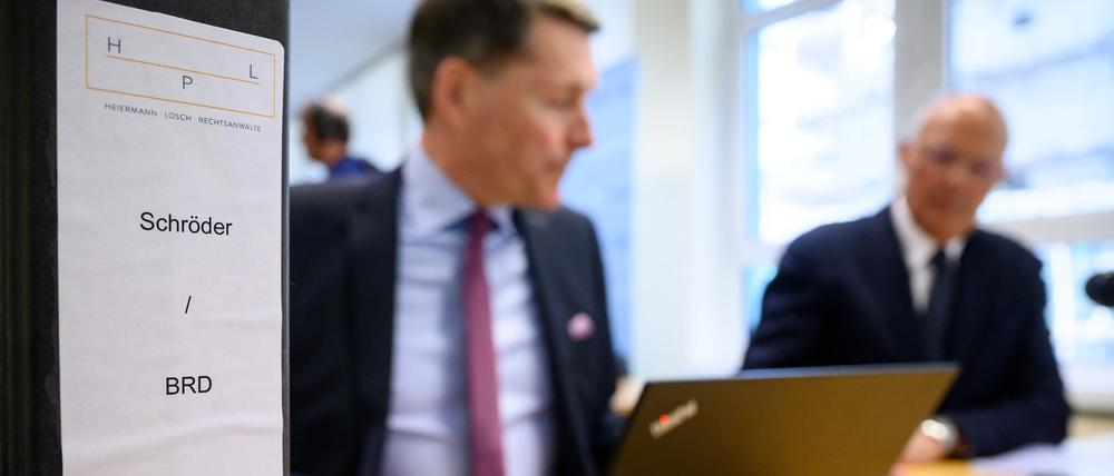 Ein Aktenordner mit der Aufschrift ·Schröder / BRD· bei der Verhandlung des Berliner Verwaltungsgerichts.  Im Hintergrund Schröders Anwälte. 