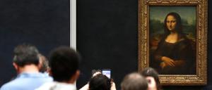 Besucher machen Fotos vor Leonardo da Vincis Meisterwerk „Mona Lisa“ im Louvre-Museum.