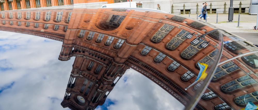 27.04.2023, Berlin: Das Rote Rathaus spiegelt sich während der Wahl des Regierenden Bürgermeisters in einem Autodach. Foto: Christoph Soeder/dpa +++ dpa-Bildfunk +++